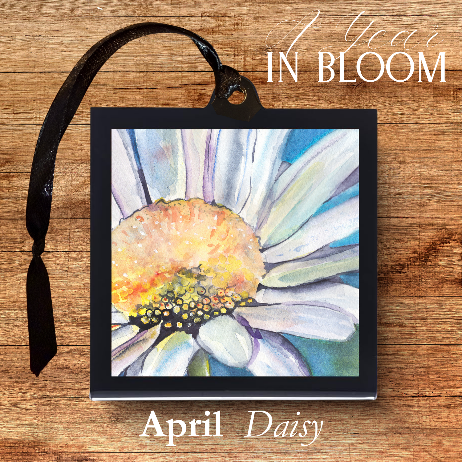 Framed artwork of a daisy with 'April Daisy' text on a wooden background