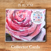 Floral collector cards set with a pink rose design on a wooden surface
