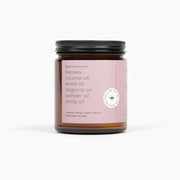 Candle jar with pink label on a white background