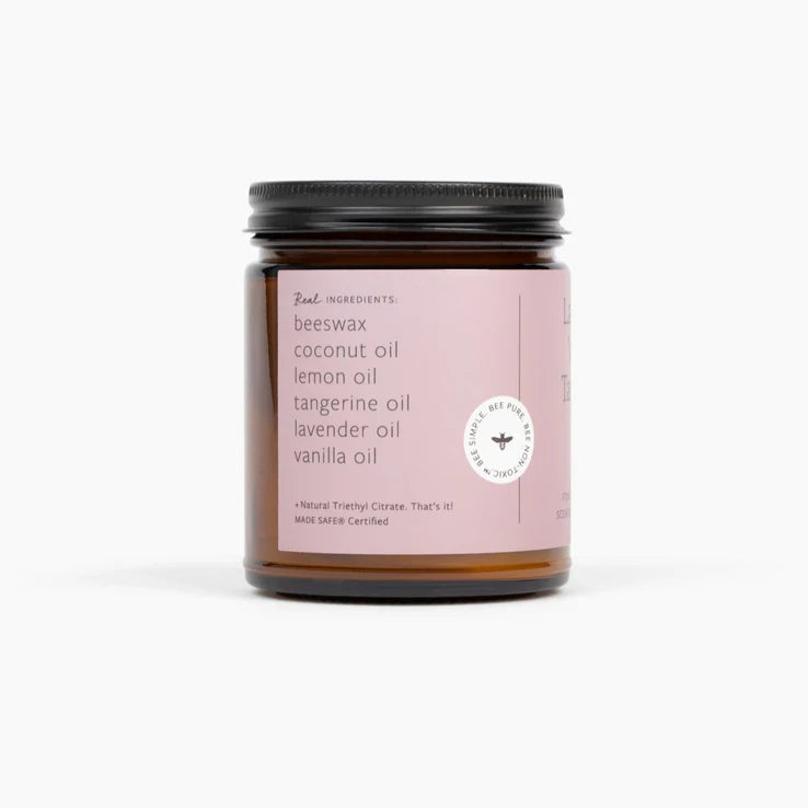 Candle jar with pink label on a white background