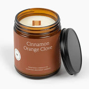 Cinnamon Orange Clove candle in a brown jar with a black lid on a white background