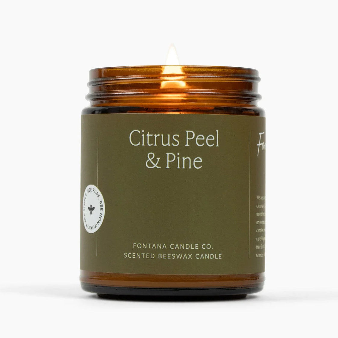 Scented candle with 'Citrus Peel & Pine' fragrance in a brown glass jar on a white background