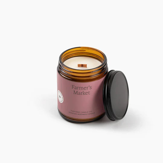 Farmer's Market Candle in an amber jar with a pink label on a white background