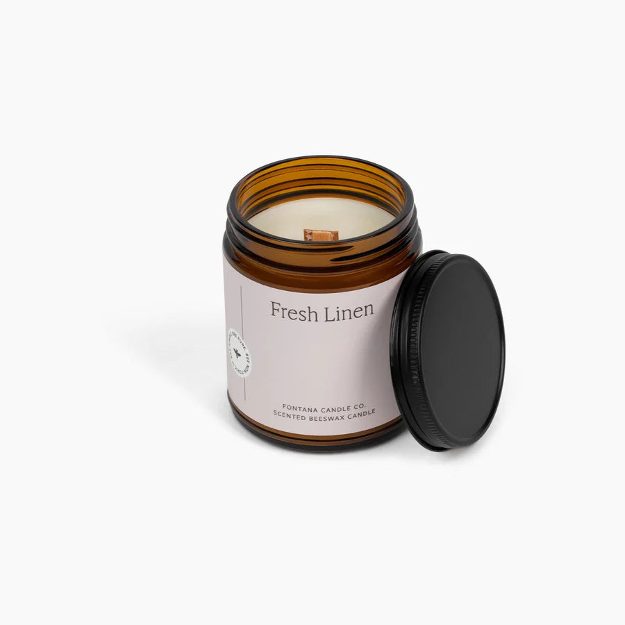 Candle in an amber jar labeled 'Fresh Linen' on a white background