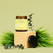 Lemongrass eucalyptus candle with greenery on a light green background