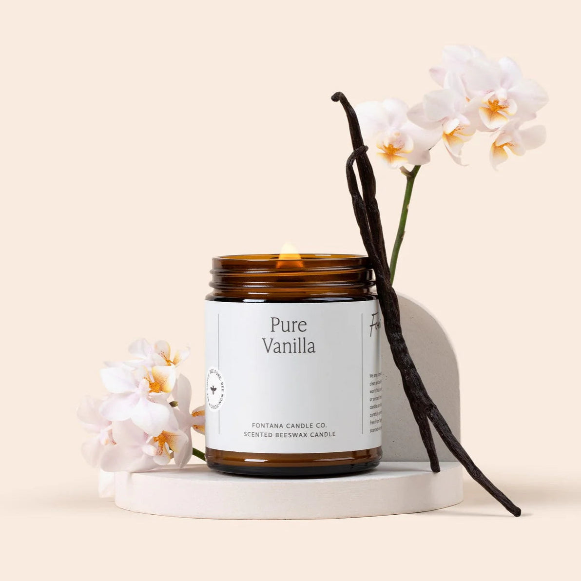 Pure Vanilla candle with vanilla beans and orchids on a beige background
