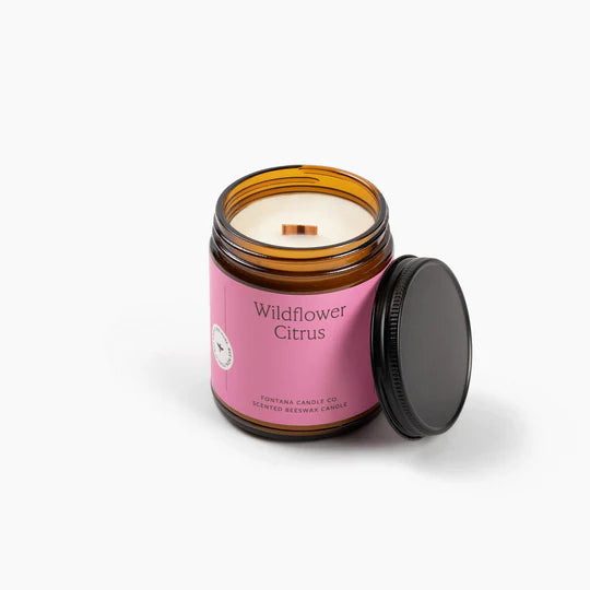 Wildflower Citrus Candle in an amber jar with a pink label on a white background