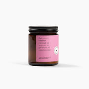 Jar of candle with pink label on a white background