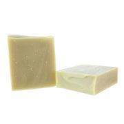 Two rectangular bars of handmade soap in a light creamy yellow color, one standing vertically and the other lying horizontally, on a plain white background.