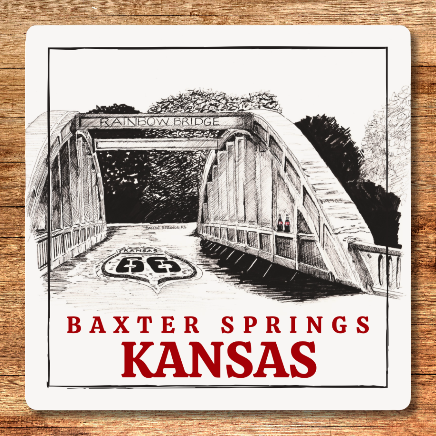 Illustration of a bridge with 'Rainbow Bridge' and 'Baxter Springs Kansas' text on a wooden surface.