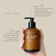 Brown bottle of Rowe Casa Organics Anti-Blemish Face Wash held in a hand with text about ingredients on a beige background