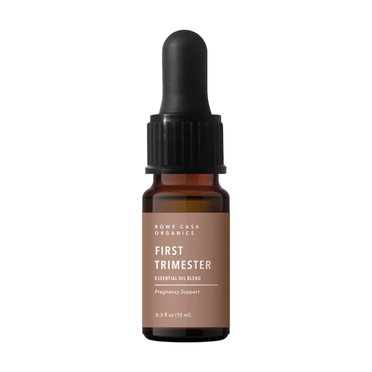 Brown essential oil bottle with dropper labeled 'First Trimester' on a white background