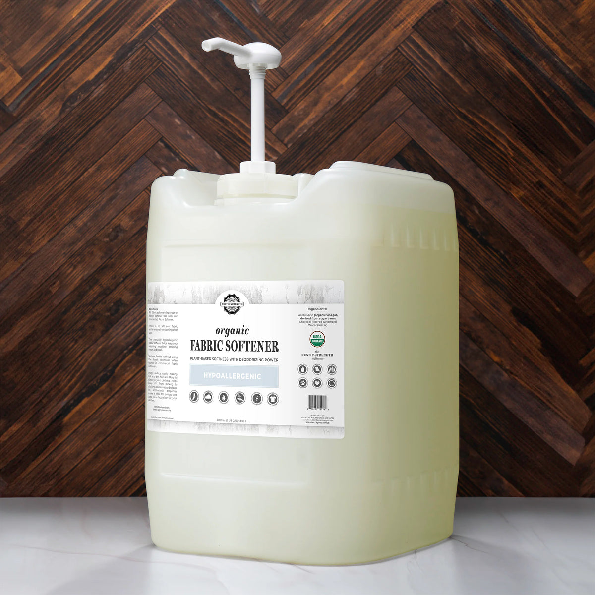 Large container of fabric softener with a pump against a wooden background