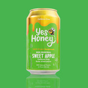 Gold and green can of 'Yes Honey' Sweet Apple soda on a green background