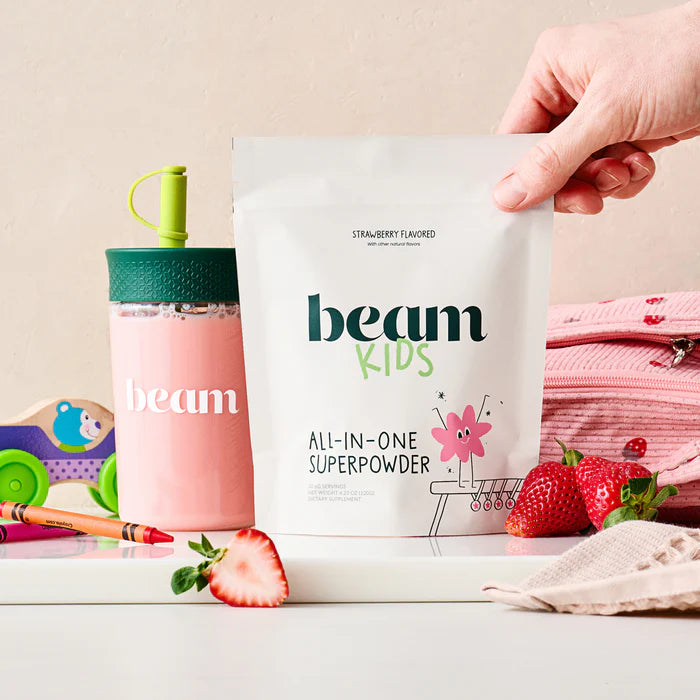 beam Kids all-in-one superpowder package with a pink drink bottle and strawberries on a light background