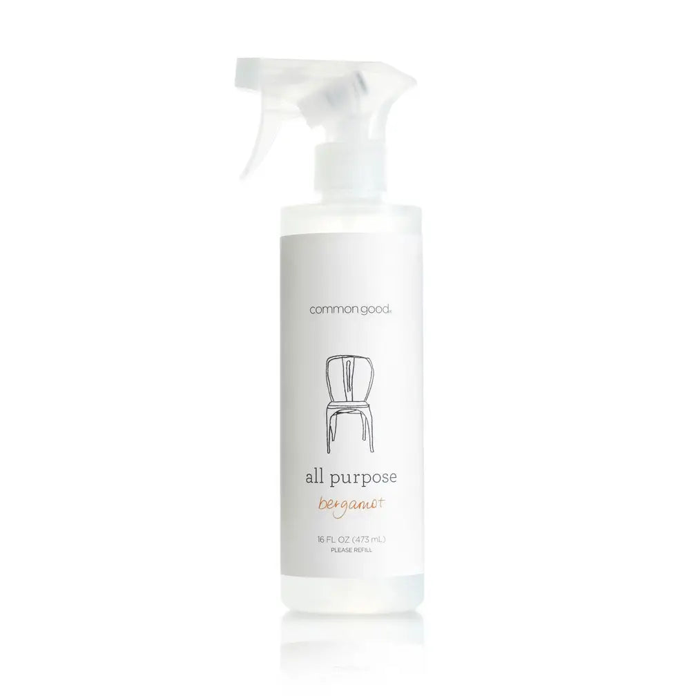 A white plastic spray bottle of Common Good All Purpose Bergamot cleaning solution on a white background with a soft reflection.