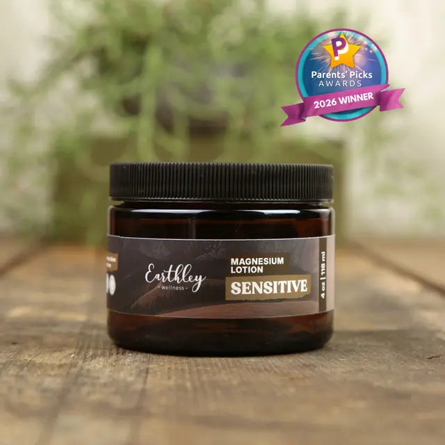 Earthley magnesium lotion jar on a wooden surface with a blurred green background