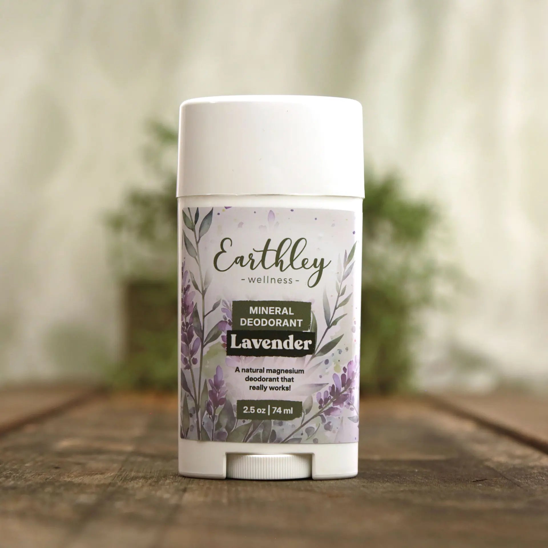 Earthley Wellness lavender deodorant stick on a wooden surface with a blurred natural background
