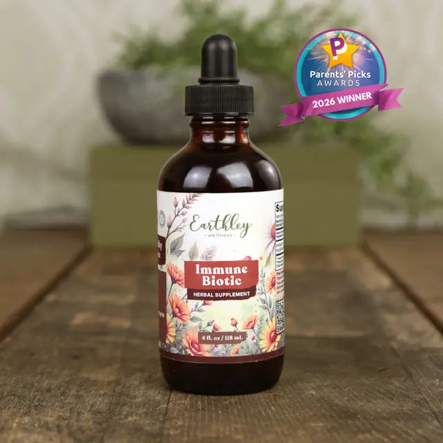 Bottle of Earthley Immune Biotic supplement on a wooden surface with a blurred background