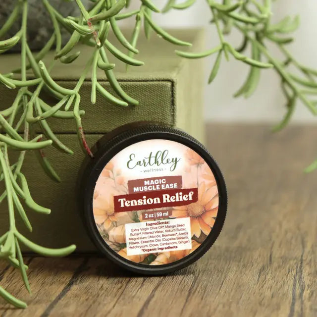 Earthley Magic Muscle Ease Tension Relief product on a wooden surface with greenery in the background