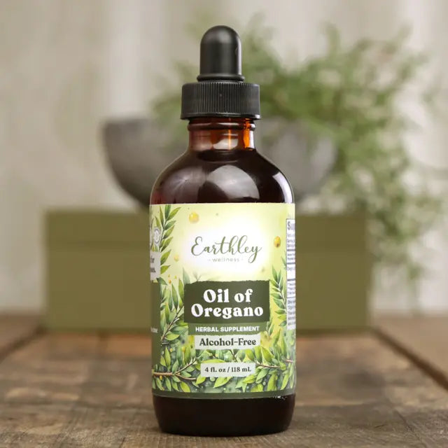 Bottle of Earthley Oil of Oregano on a wooden surface with a blurred background