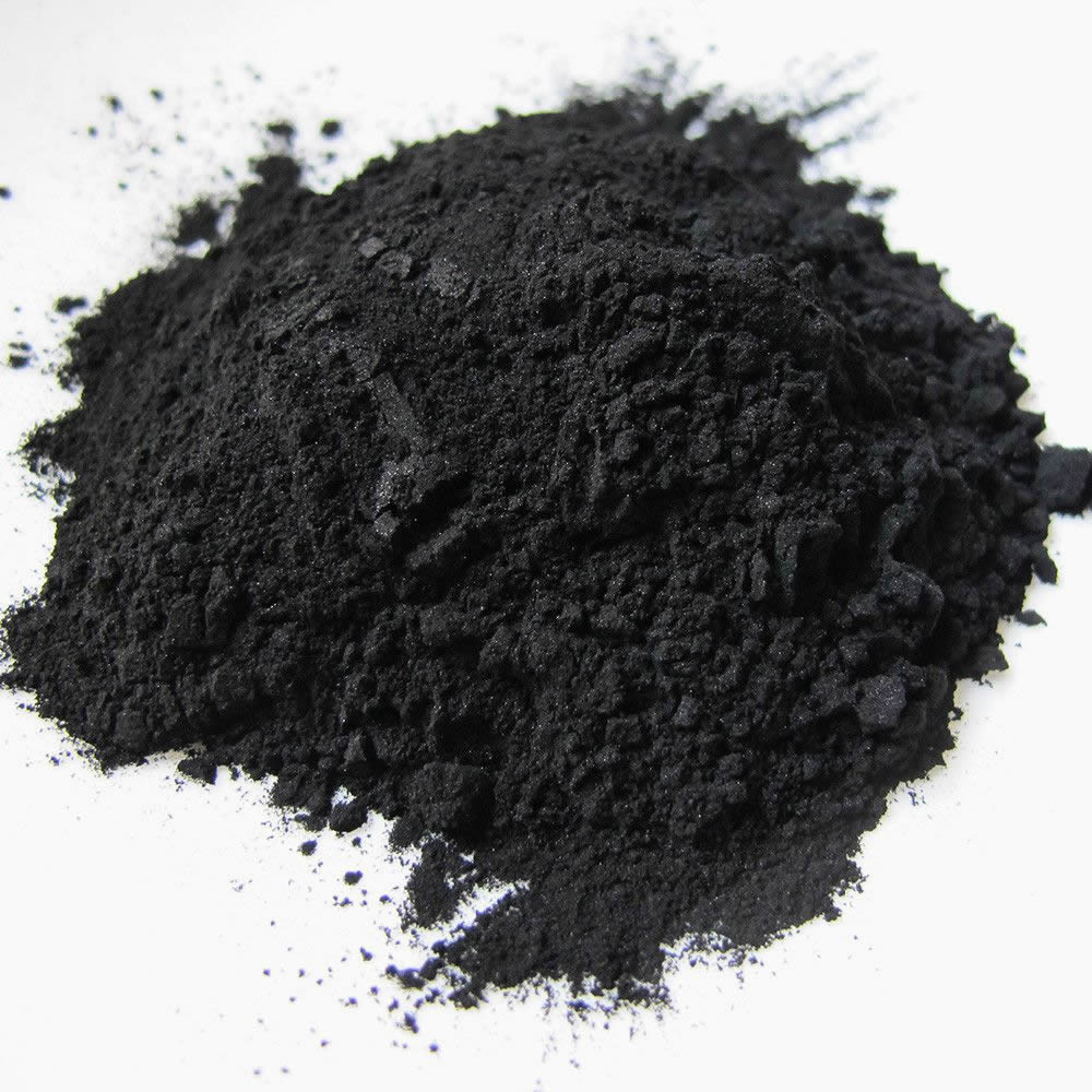 Rise Apothecary  Pile of black activated charcoal powder on a white background