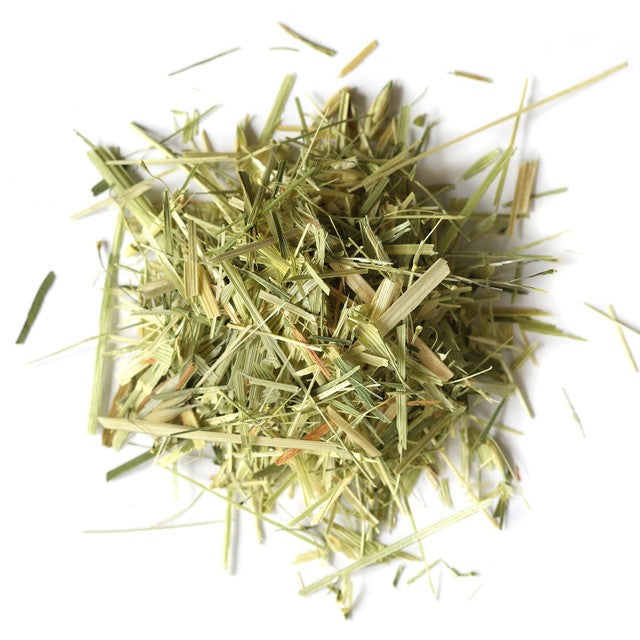 A pile of dried, shredded green and yellow herbal grass or leaf material, likely used as a tea or supplement ingredient, photographed on a solid white background.