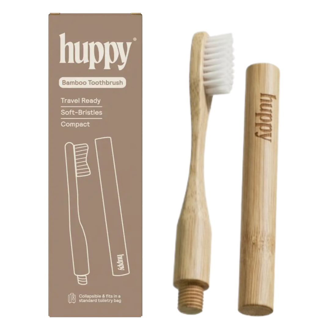A Huppy bamboo toothbrush set with its packaging box, showing the bamboo handle, white bristles, and a separate bamboo travel case on a plain white background.