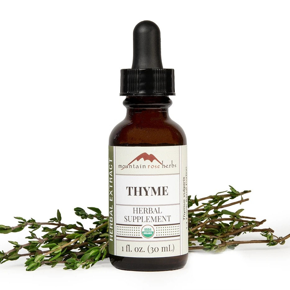 An amber glass dropper bottle of Mountain Rose Herbs Thyme Herbal Supplement, displayed on a white background with fresh green thyme sprigs.