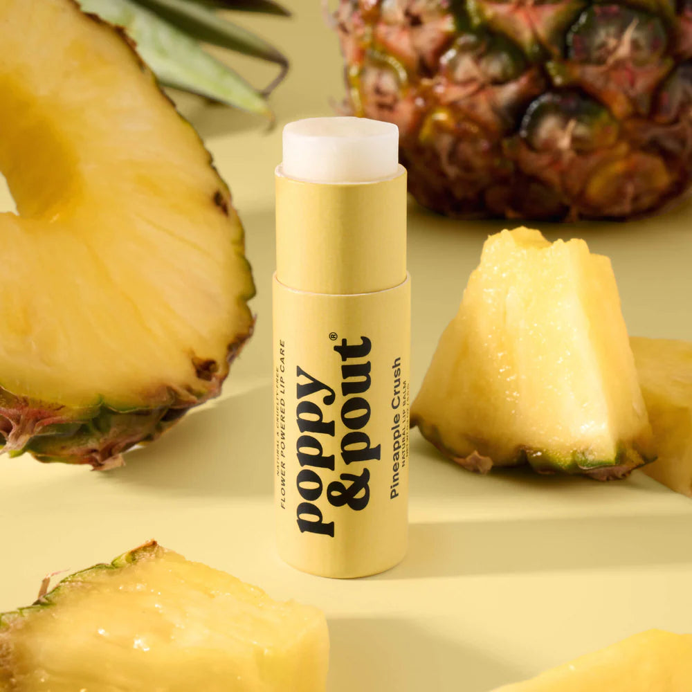 Balm with 'Poppy & Pout' branding surrounded by pineapple slices on a yellow background
