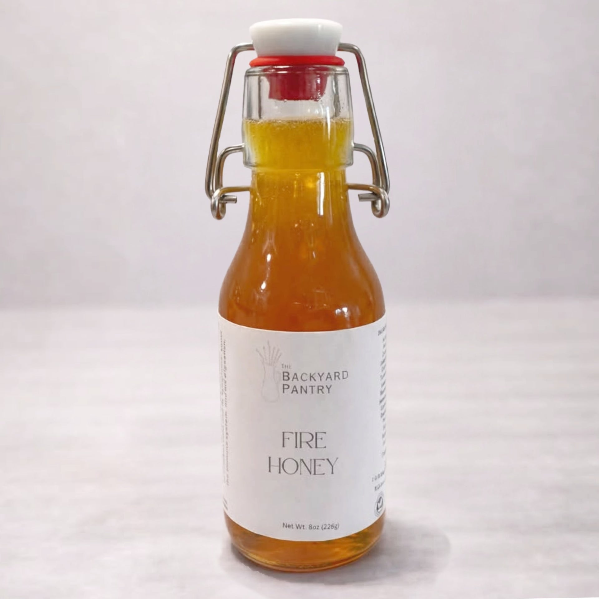 Bottle of 'Fire Honey' from The Backyard Pantry on a white background