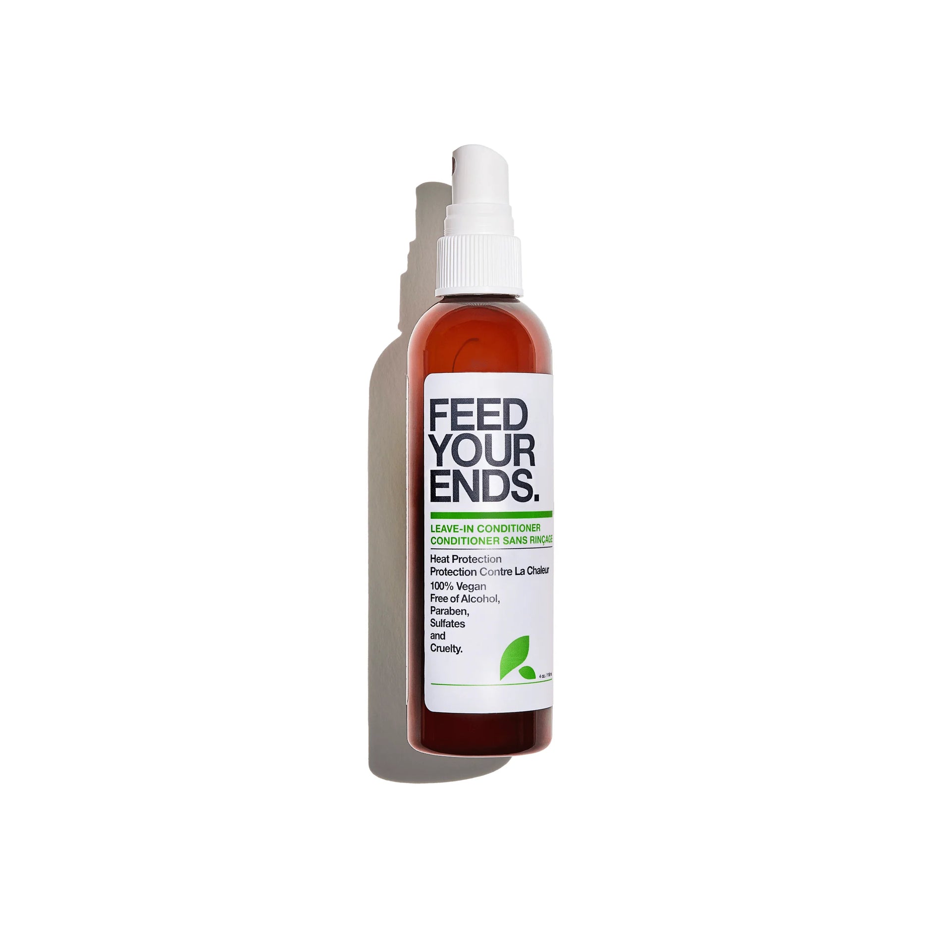 A bottle of Feed Your Ends Conditioner Spray on a white background with a soft shadow. The bottle is amber brown with a white spray cap and a white label featuring black and green text.